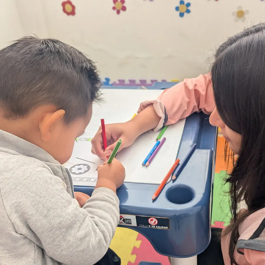 Terapeuta de KALMS acompañando a un niño mientras dibuja