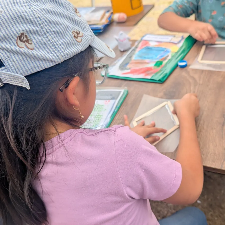 Niña trabajando con material sensorial en el campamento de verano
