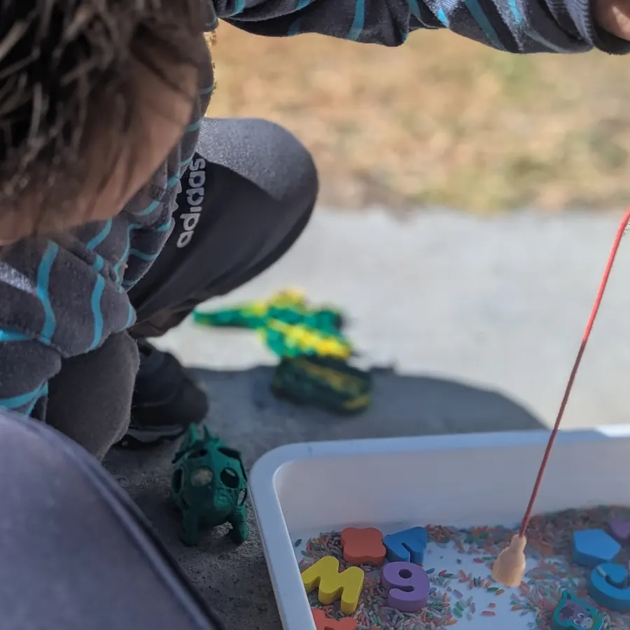 Niño jugando a pescar letras en una actividad de psicopedagogía